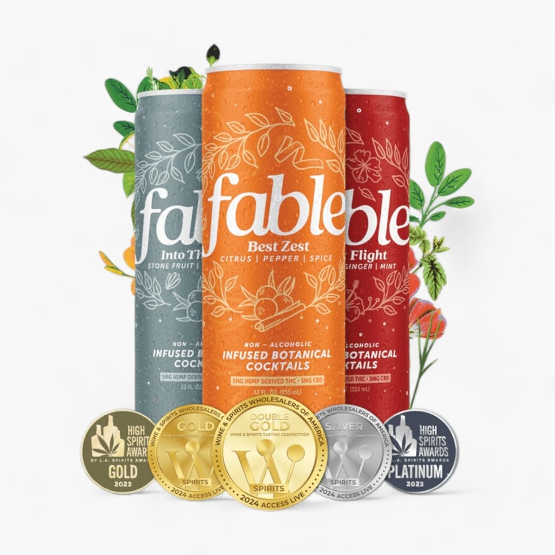 Three 'fable' branded cans with decorative elements and awards