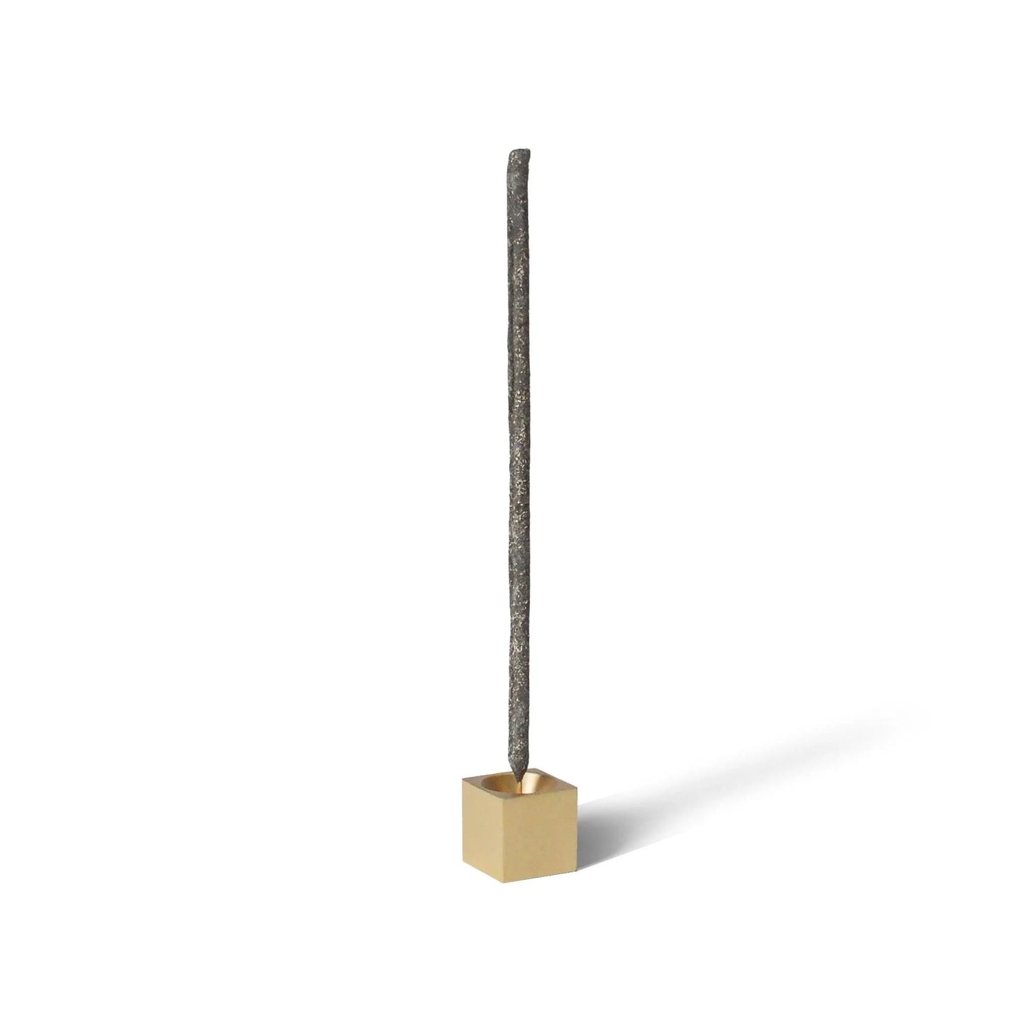 Modern brass incense holder displayed with burning incense stick.