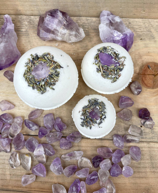 Bath bombs with lavender and amethyst crystals on a wooden surface