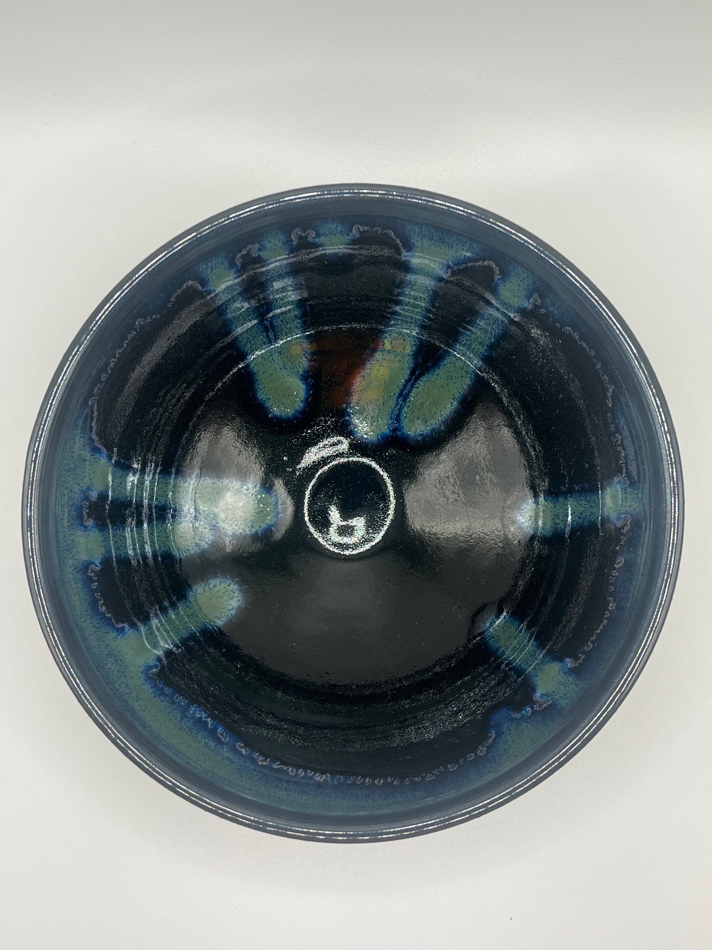 Ceramic bowl with blue and green patterns on a white background