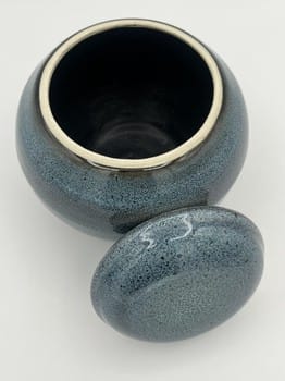 Blue ceramic jar with a matching lid on a white background