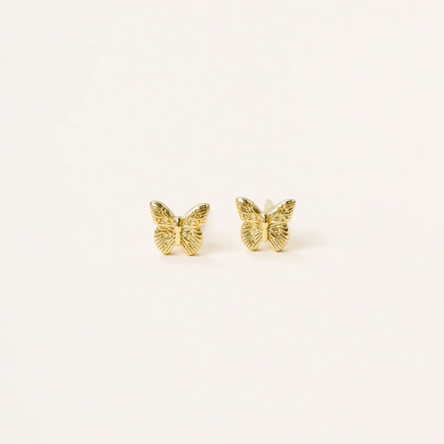 Gold butterfly earrings on a white background