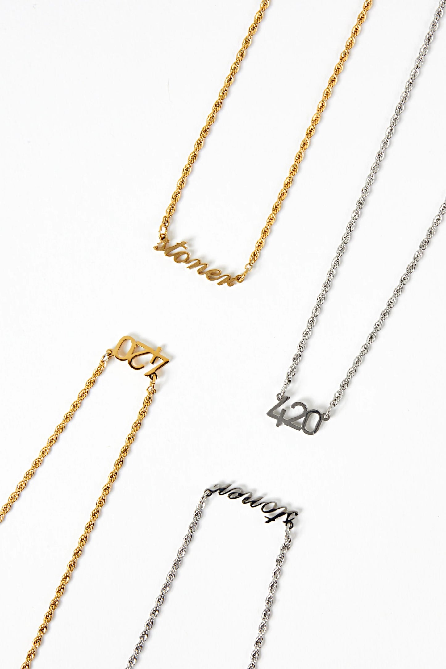 Four necklaces with different text on them displayed against a white background.