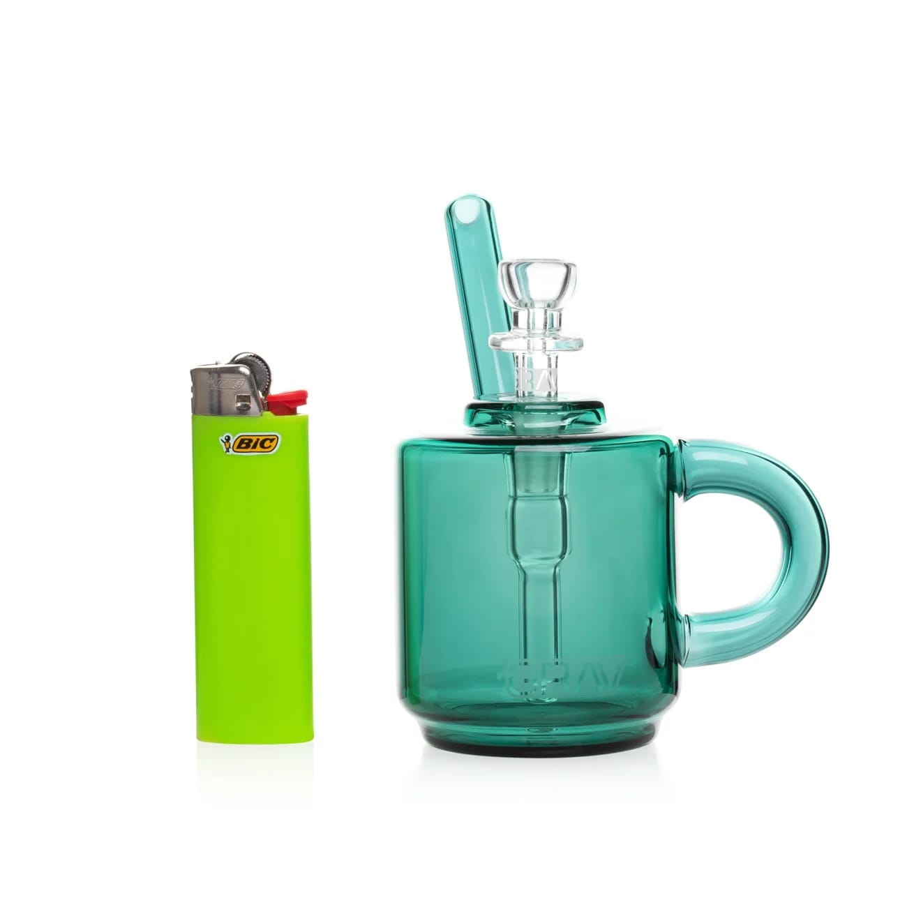 Green glass mug with handle, BIC lighter, and small glass container on a white background