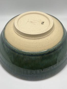 Ceramic bowl with green glaze on a white background
