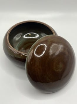 Brown ceramic container with lid on a white background