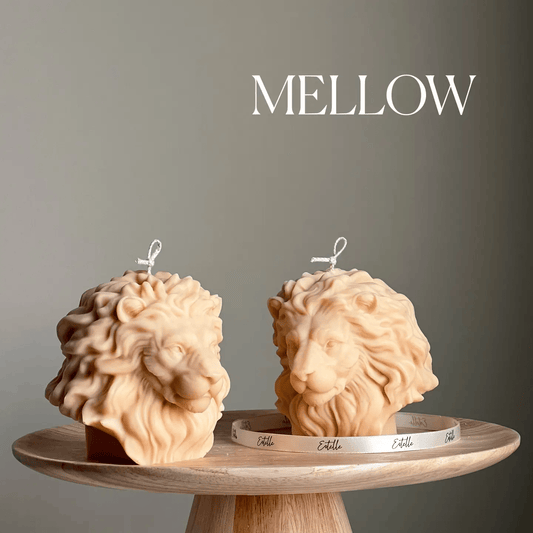 Two lion-shaped candles on a wooden stand with 'MELLOW' text above.