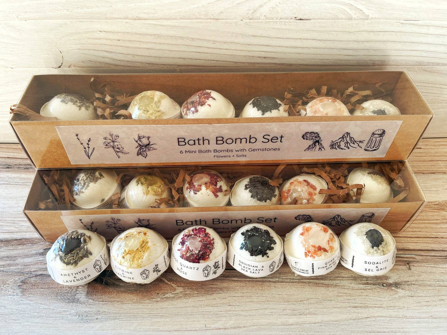 Bath bomb set with various scents displayed in a cardboard box on a wooden surface.