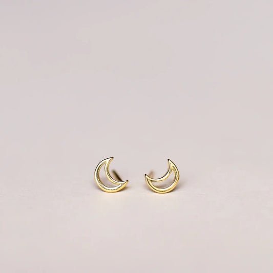 Gold crescent moon earrings on a light gray background