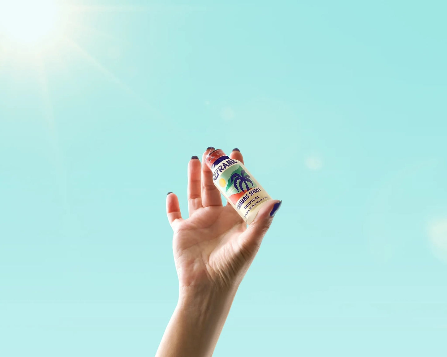Hand holding a small 2oz bottle of Reframe cannabis spirit