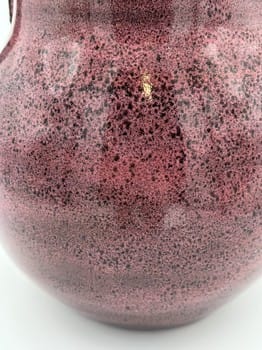 Close-up of a textured purple vase on a white background