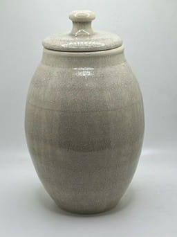 Stoneware jar with a lid on a white background