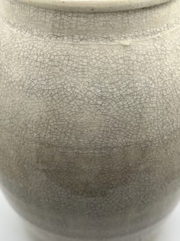 Close-up of a ceramic jar with a textured surface on a white background