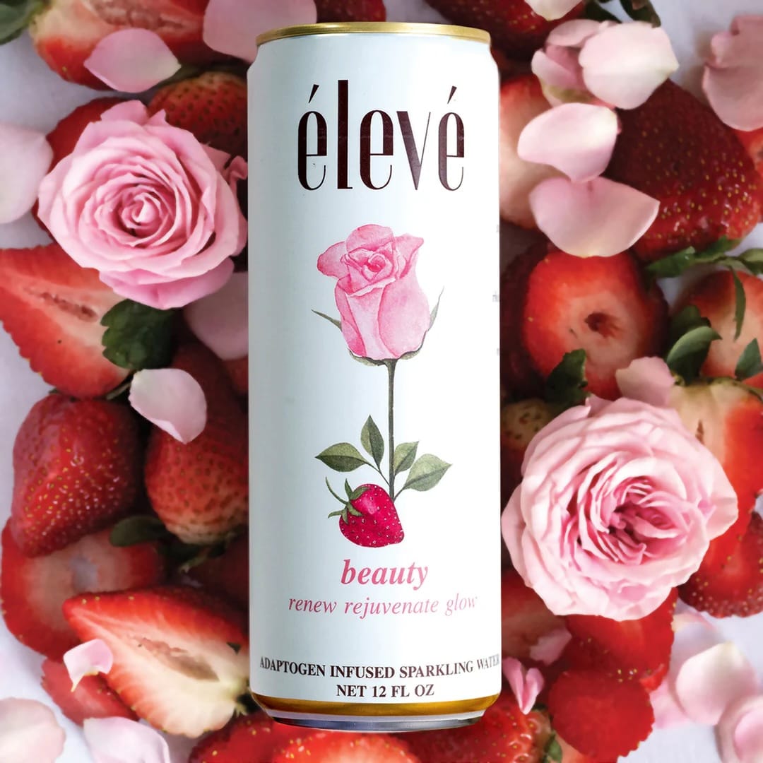 Can of elevé beauty sparkling water surrounded by strawberries and pink roses