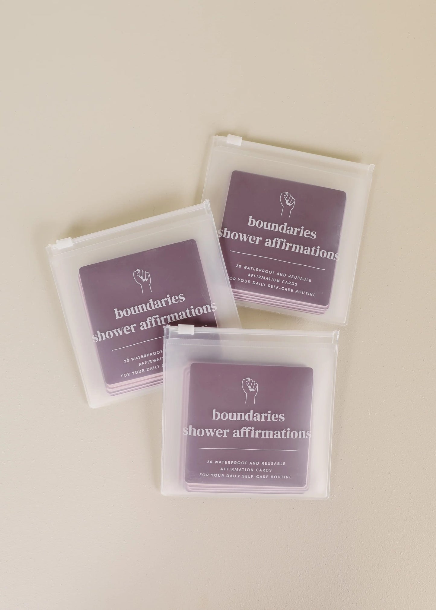 Three packages of 'boundaries shower affirmations' on a beige background