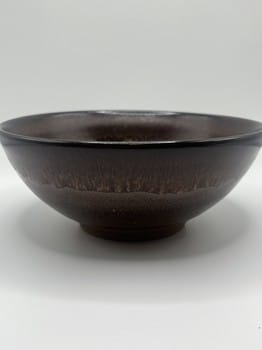 Dark brown ceramic bowl on a white background