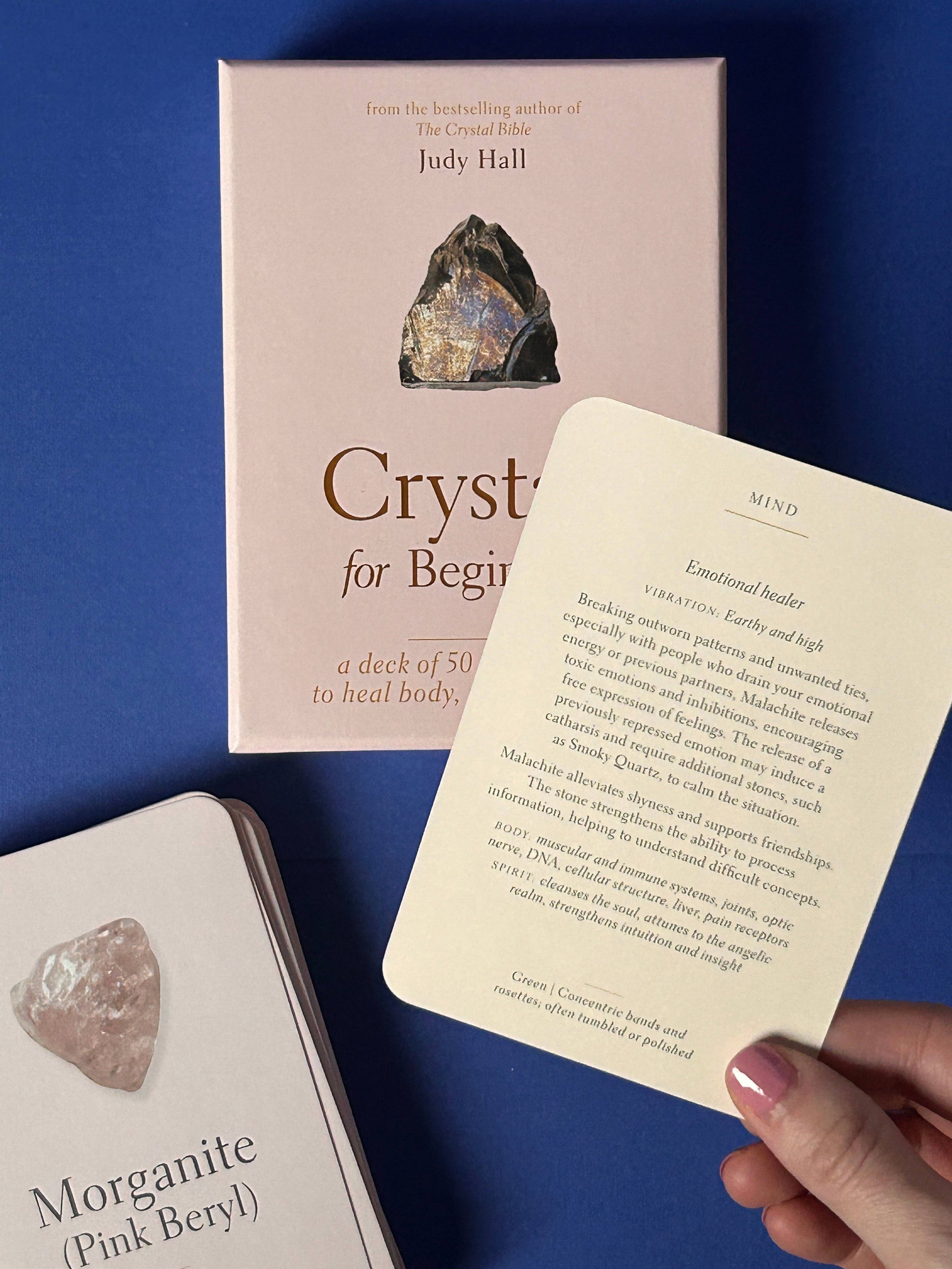 Crystal card deck with a pink box and morganite stone on a blue background