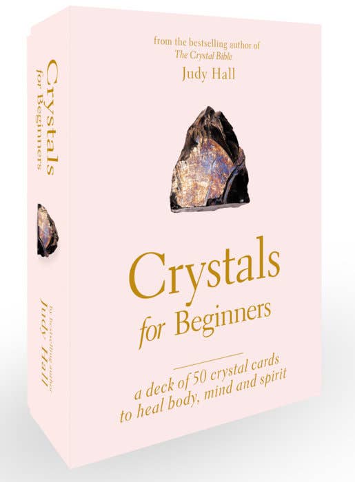 Card deck packaging for 'Crystals for Beginners' by Judy Hall on a light pink background.