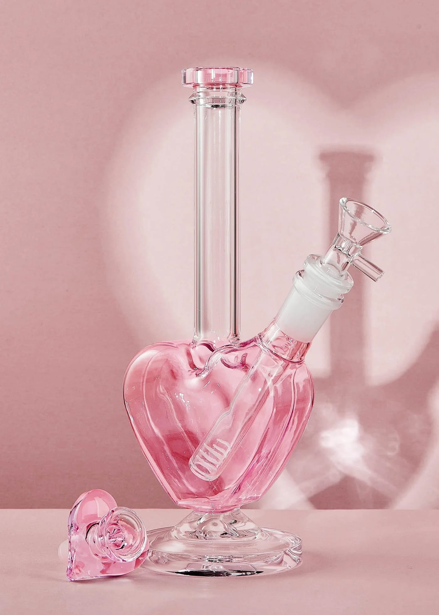 Pink glass heart-shaped water pipe on a pink background