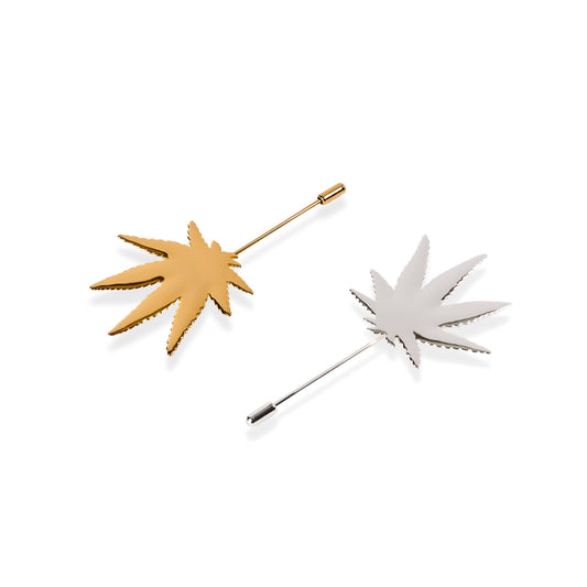 Two leaf-shaped pins, one gold and one silver, on a white background.