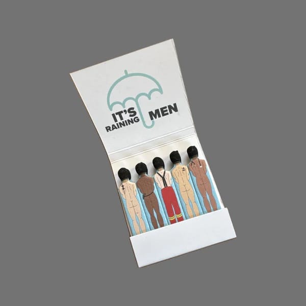 Matchbook with illustration of men under an umbrella and text 'It's Raining Men' on a gray background