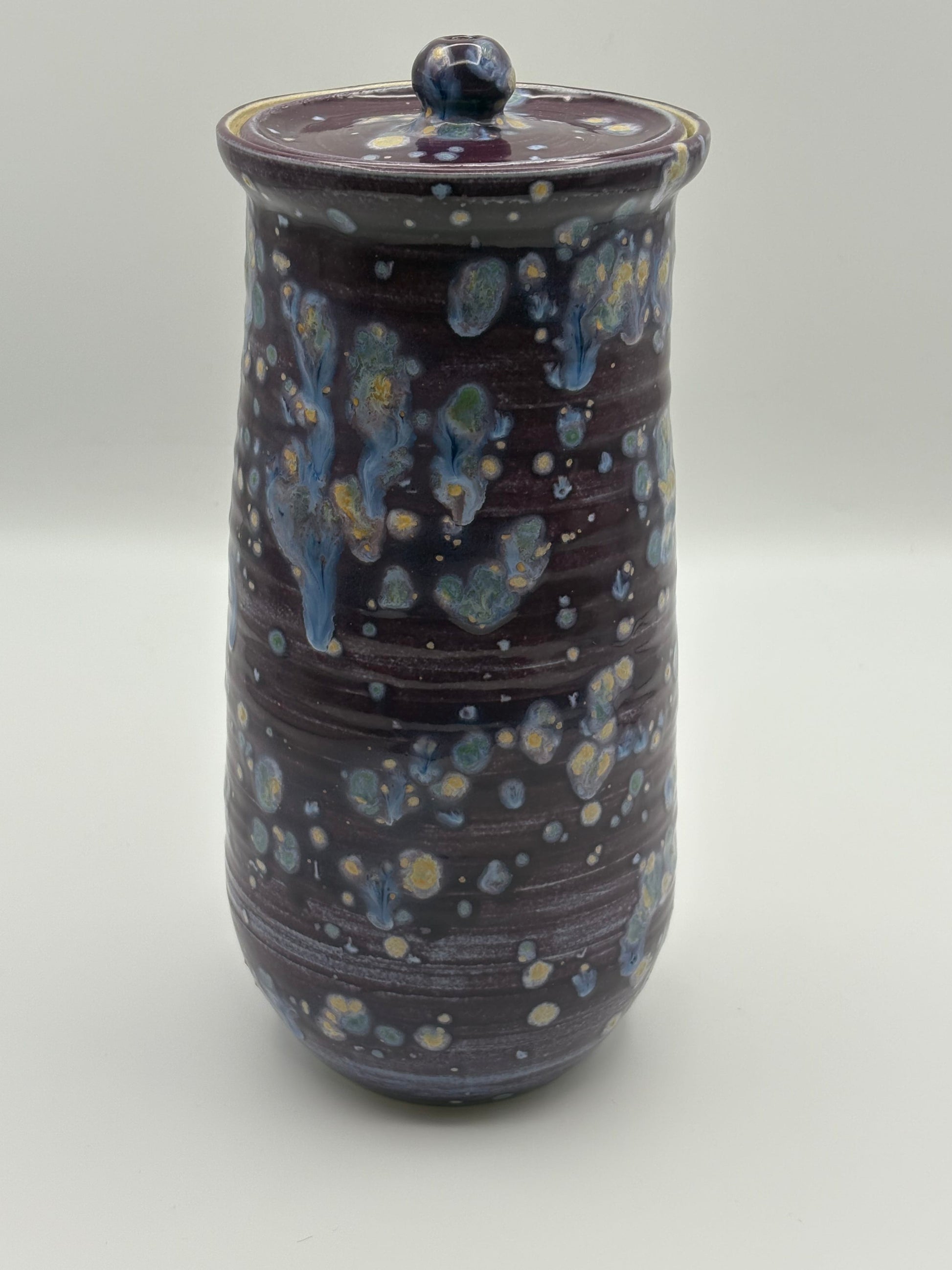 Ceramic jar with a lid featuring a speckled design 