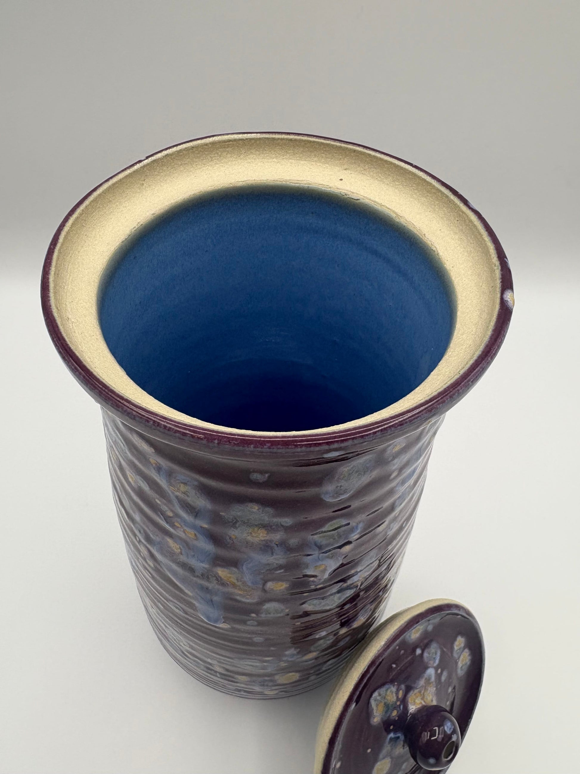 Ceramic jar with blue interior and purple exterior