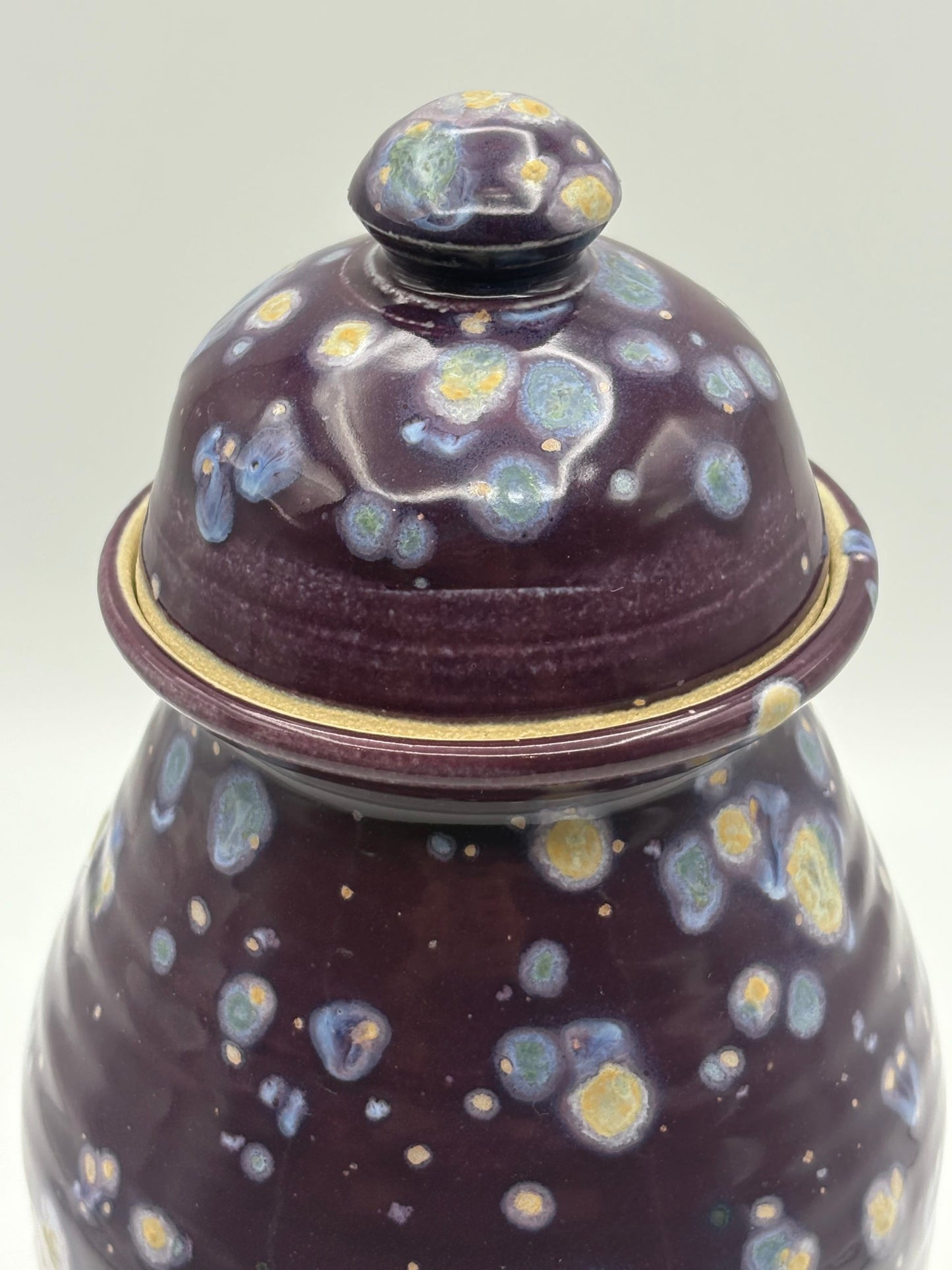 Ceramic jar with a lid featuring a speckled design 